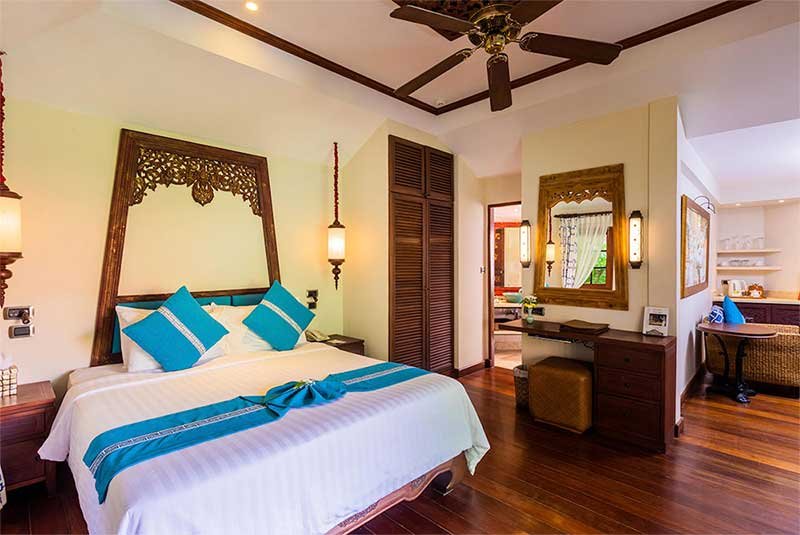 Large bed in cottage with blue decor at Anavana Beach Resort