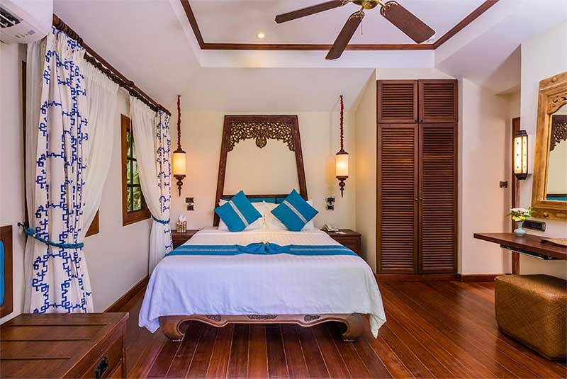 bed and more interior of cottage with blue decor at Anavana Beach Resort